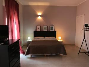 奥斯图尼Apartment Antonella的一间卧室配有一张床、一台电视和一张三脚架
