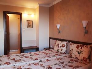 索佐波尔Family Hotel Radiana的一间卧室配有一张带花卉床罩的床