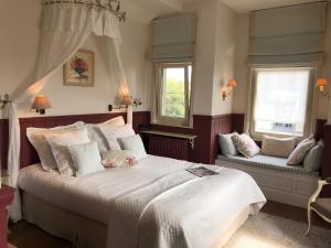 米德尔克尔克Bed & Breakfast Het Zilte Zand - Westende - Middelkerke - De Kust的一间卧室设有一张大床和两个窗户。