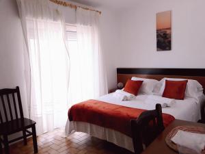 奥德赛克斯Casa Dorita的一间卧室配有带白色和红色枕头的床