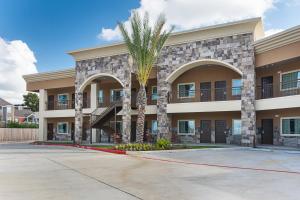 休斯顿Econo Lodge Inn & Suites Houston NW-Cy-Fair的前面有棕榈树的建筑