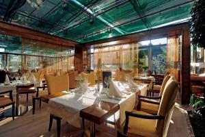 罗加斯卡斯拉提纳Grand Hotel Donat Superior & Wellness Center的用餐室设有桌椅和窗户。