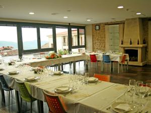 埃尔托尔诺阿尔伯赫尔特酒店的用餐室配有桌椅和酒杯