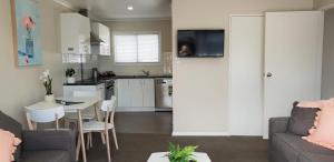 罗托鲁瓦Rose Apartments Unit 3 Central Rotorua - Accommodation & Spa的厨房以及带沙发和桌子的客厅。