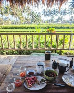 特特巴图Les Rizieres Lombok - Tetebatu的一张木桌,上面有盘子