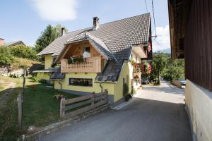 博希尼Farmhouse pri Miklavu的黄色的房屋设有门廊和阳台