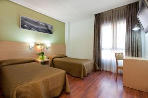 马德里布拉沃穆里略4C酒店的酒店客房设有两张床和窗户。