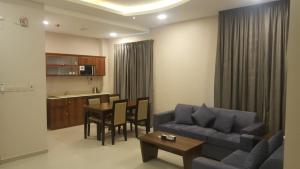 胡富夫Al Nakhla Aparthotel的带沙发和桌子的客厅以及厨房。
