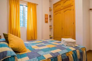 内尔哈Finca El Valle的一间卧室配有一张带五颜六色被子的床
