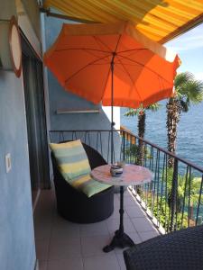 隆科索普拉阿斯科纳圣马蒂诺公寓的阳台配有桌子和雨伞。