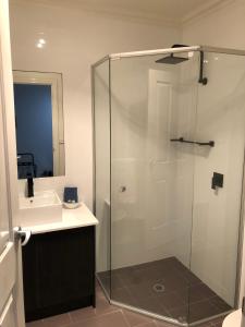 仙女港港口精品公寓的一间带玻璃淋浴和水槽的浴室