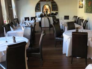 博尔肯Gasthof Einhaus的用餐室配有白色桌子和黑色椅子