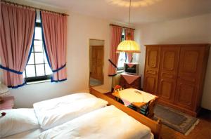 博尔肯Gasthof Einhaus的一间卧室设有两张床、一张桌子和一个窗口