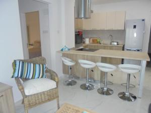 利马索尔Kermia Court - Beach-front, modern 2 bedroom -sleeps 6的厨房设有带凳子和柜台的酒吧