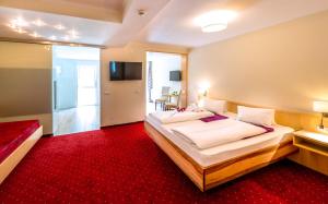 旧明斯特Panorama Hotel Traunstein的酒店客房,配有床铺和红地毯