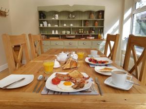 西威特灵Willow House B&B的一张木桌,上面摆放着早餐食品和饮料