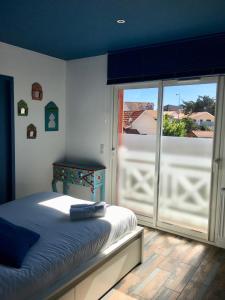 拉卡诺La COLOC的一间卧室设有一张床和一个滑动玻璃门