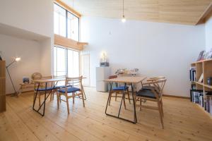 屋久岛Ananda Chillage Yakushima的带2张桌子和椅子的房间以及厨房