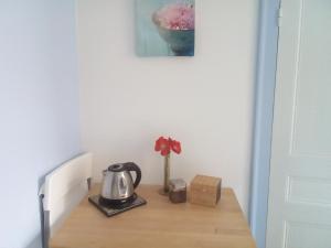 莱桑德利Chambre Saint-Sauveur的茶壶和花的桌子