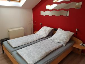 SpirkelbachHöllenbergblick的红色墙壁的客房内的两张床