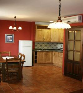 巴埃萨西斯之家旅馆的厨房配有桌子和白色冰箱。
