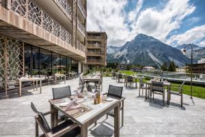 阿罗萨Valsana Hotel Arosa的一间设有桌椅的餐厅,享有山景