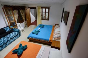 阿约拉港加拉帕戈斯明珠住宿加早餐旅馆的一间带床和沙发的小卧室