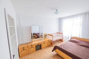 BohuslavApartment on Polevaya 44/12的一间卧室配有一张床,梳妆台上配有镜子