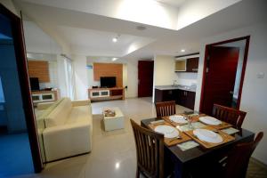 泗水高点服务式公寓酒店的一间带桌椅的客厅和一间厨房
