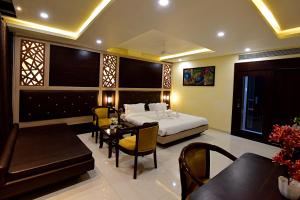 博帕尔Hotel Dayal Shree Paradise的卧室配有一张床和一张桌子及椅子