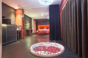 巴加Fahrenheit Hotels & Resorts的一间设有浴缸的客房,浴缸内装满红色的花瓣