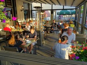 维斯可可Hotel Café Restaurant "De Kroon"的一群坐在餐厅桌子上的人