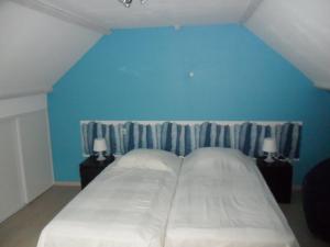 Fresnicourt-le-Dolmenle gite d'olhain的一间卧室设有一张蓝色墙壁的大床