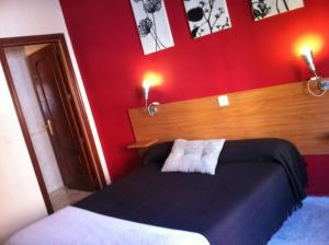 卡塞雷斯海王星旅馆 的一间卧室设有一张床和红色的墙壁
