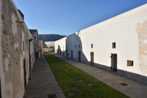 菲纳莱利古雷Locanda La Fortezza的两座白色建筑之间的一条小巷