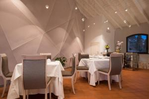 菲纳莱利古雷Locanda La Fortezza的一间配备有白色桌椅的用餐室