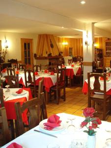 圣洛伦索-德埃斯科里亚尔Hotel Tres Arcos的餐厅配有桌椅和红色桌布