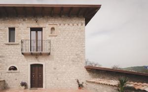 格罗塔米纳尔达Il Vecchio Frantoio的一座石头建筑,旁边设有阳台