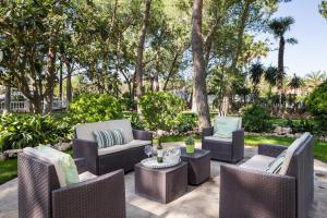 莱利亚纳El Oasis Villa Resort的庭院配有桌椅和树木