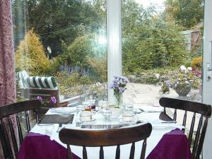 阿什伯恩康普顿住宿加早餐旅馆的一张桌子,上面有紫色的桌布和窗户