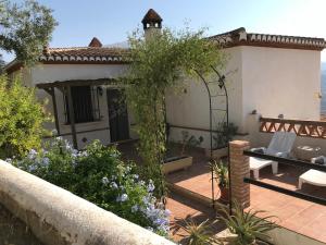 Pinos del ValleJardin Andaluz Appart Alhambra的房屋设有带桌子的庭院和花园