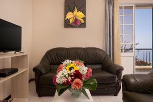 蓬他达维托亚Casa do Miradouro的客厅配有长沙发,花束环绕