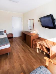 彼得罗扎沃茨克卡列里亚Spa酒店的一间卧室配有一张床,墙上配有电视