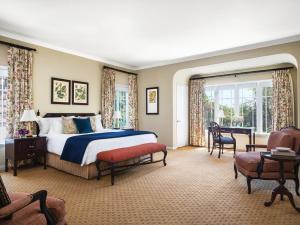 帕萨迪纳帕萨迪纳亨廷顿朗廷酒店的卧室配有一张床和一张桌子及椅子