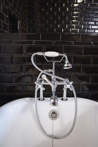 弗洛伦斯GunRunner Boutique Hotel的浴室设有带淋浴的白色浴缸。
