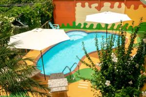 卡维塔Hotel Boutique La Casa de las Flores的一个带两把遮阳伞和滑梯的游泳池