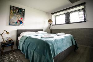 考纳斯G - Owl Jazz - Modern and spacious loft type apartment 8 with free private parking的一间卧室配有一张床,上面有两条毛巾