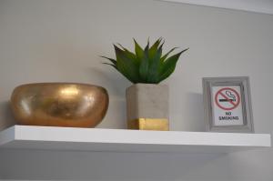 德班维尔Columbine Place的带有盆栽和禁止吸烟标志的架子