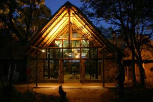 PhokengKedar Heritage Lodge, Conference Centre & Spa的一间玻璃房子,晚上有三角形屋顶