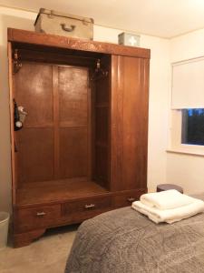 蒂尔堡The Old Garage的卧室内的大型木制橱柜,配有床